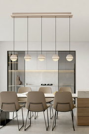 Moderne LED-Pendelleuchte über einem Esstisch, seitliche Perspektive