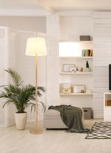 Stehleuchte mit hellem Lampenschirm in modernem Wohnzimmer, seitliche Perspektive