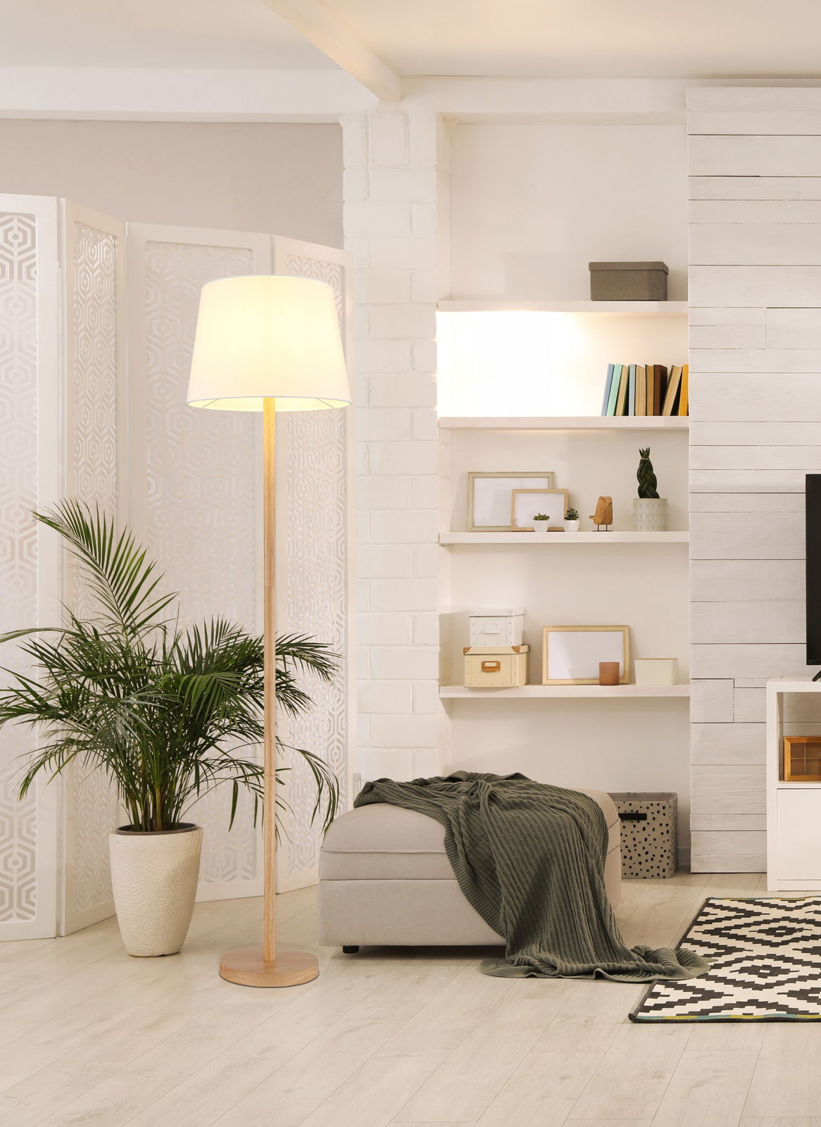 Stehleuchte mit hellem Lampenschirm in modernem Wohnzimmer, seitliche Perspektive