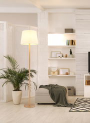 Stehleuchte mit hellem Lampenschirm in modernem Wohnzimmer, seitliche Perspektive