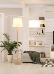 Stehleuchte mit hellem Lampenschirm in modernem Wohnzimmer, seitliche Perspektive