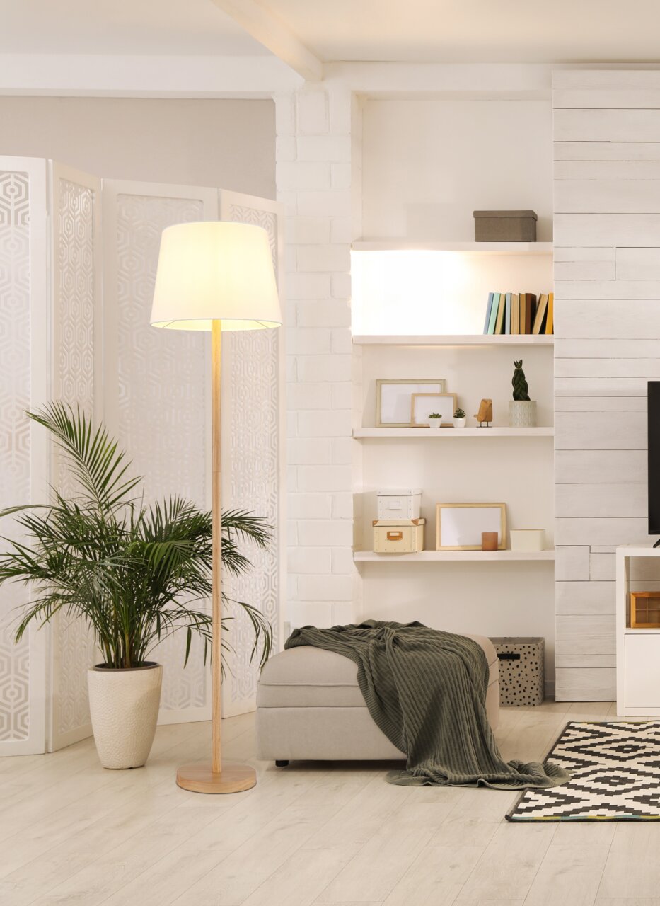 Stehleuchte mit hellem Lampenschirm in modernem Wohnzimmer, seitliche Perspektive