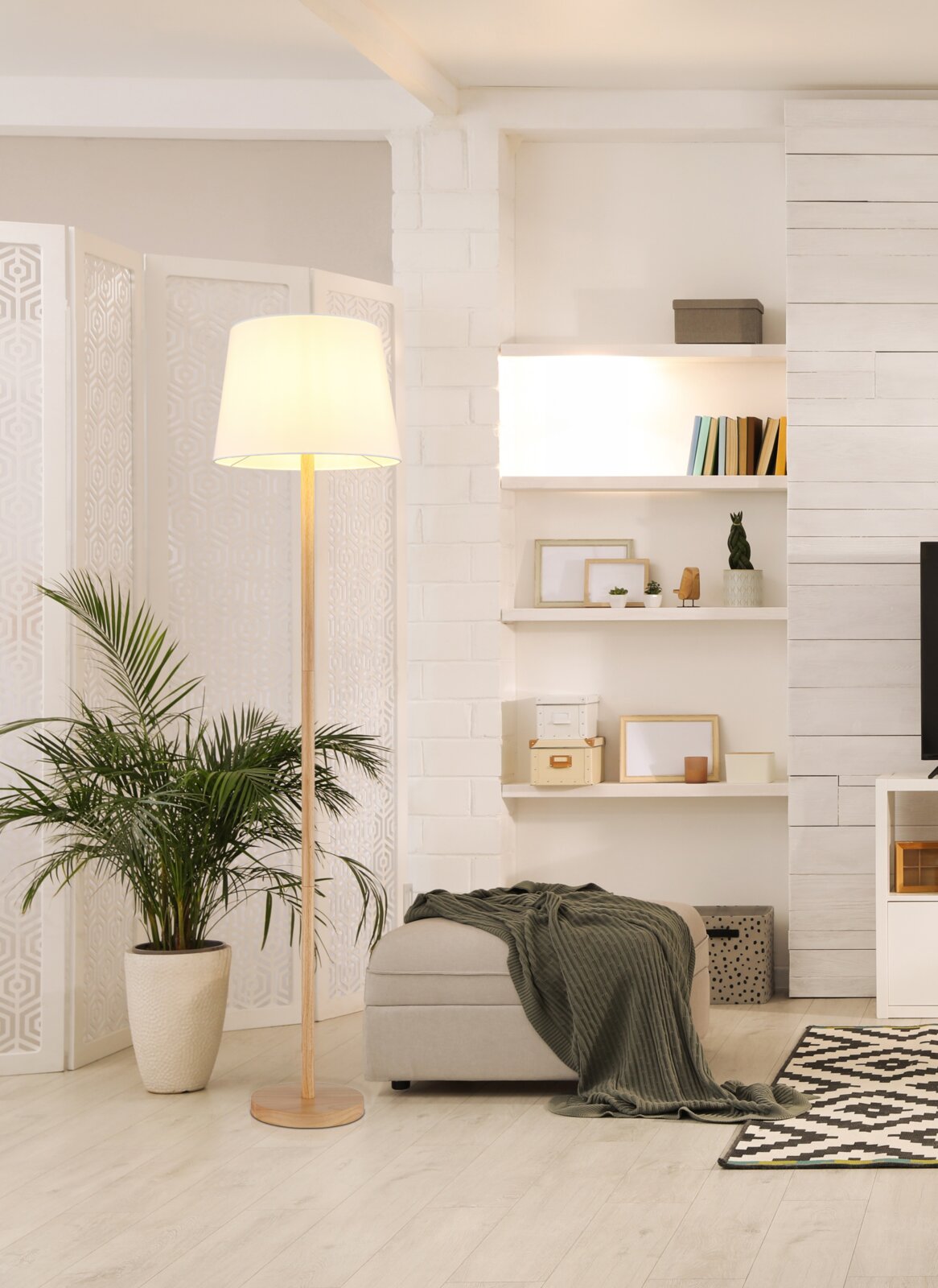 Stehleuchte mit hellem Lampenschirm in modernem Wohnzimmer, seitliche Perspektive