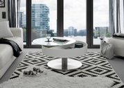 Moderner Couchtisch mit rundem, drehbarem Glasaufsatz und Stauraum, in einem stilvollen Wohnzimmer mit Blick auf die Stadt.