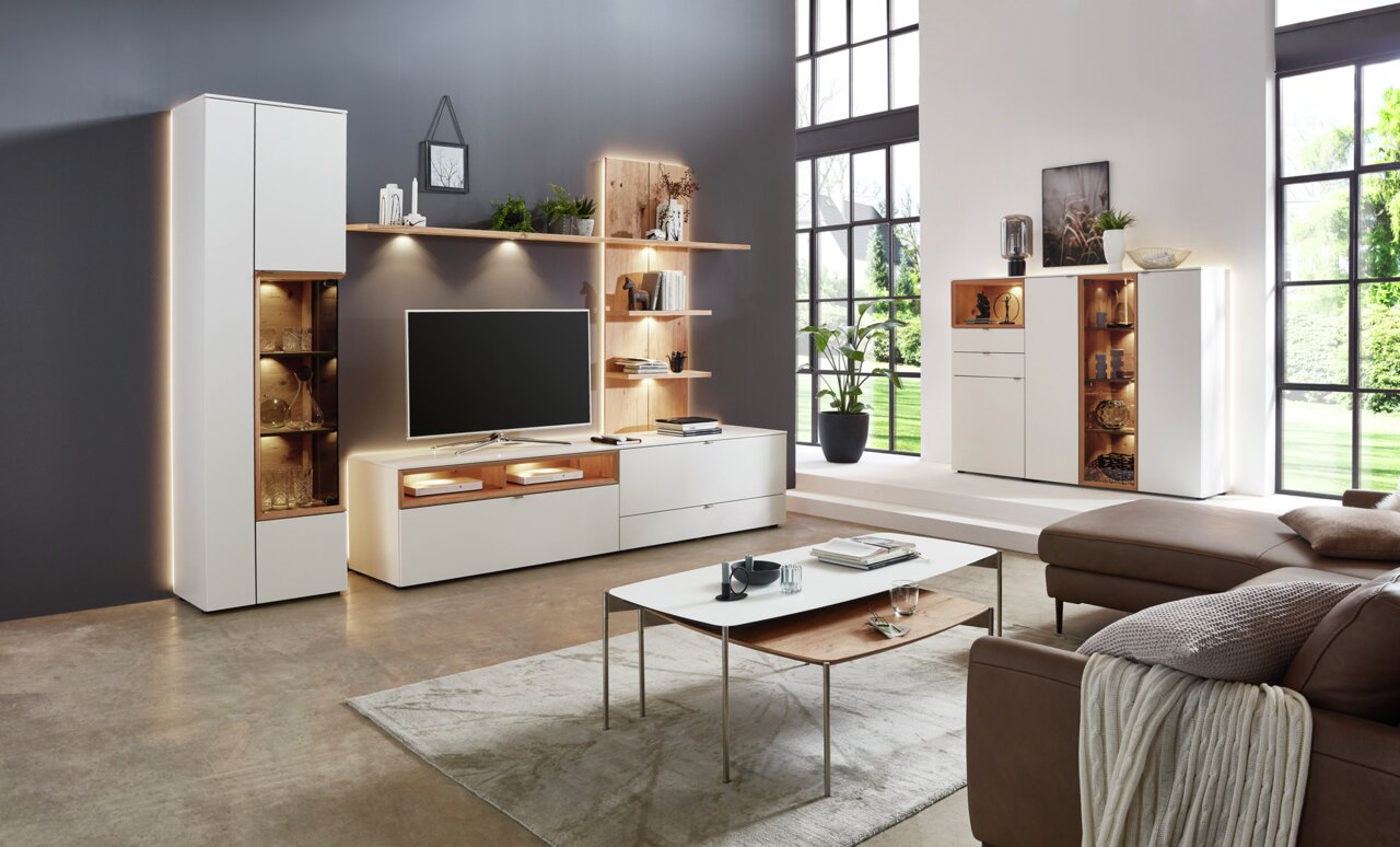 Moderne Wandkombination in einem stilvollen Wohnzimmer mit TV, Regalen und Schränken, seitliche Perspektive.