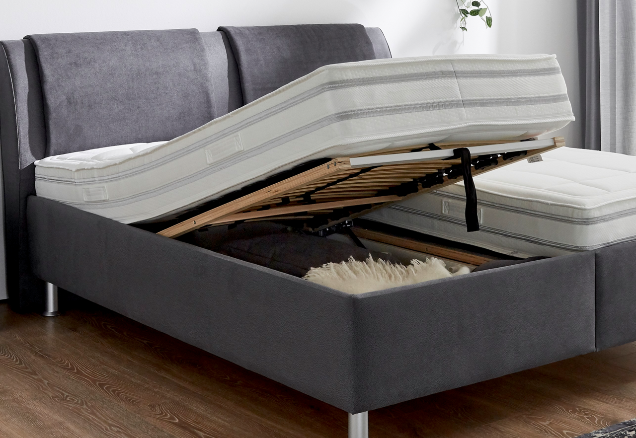 Polsterbett mit hochgeklappter Matratze und Lattenrost, seitliche Perspektive