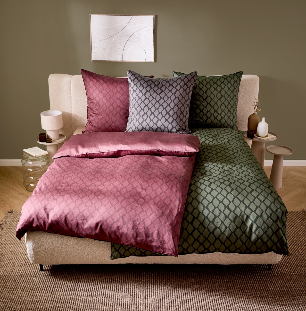 Wendebettwäsche in einem modernen Schlafzimmer, mit einer Seite in Rosa und der anderen in Grün, aus der Perspektive von vorne fotografiert.