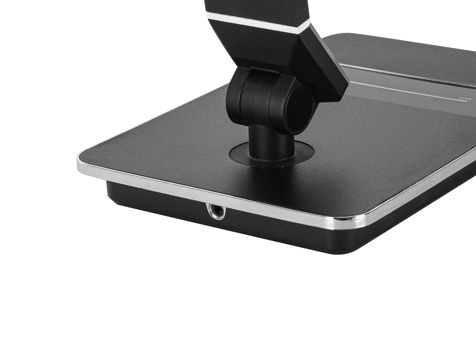 Nahaufnahme der Basis einer modernen schwarzen Schreibtischleuchte mit verstellbarem Arm, seitliche Perspektive.