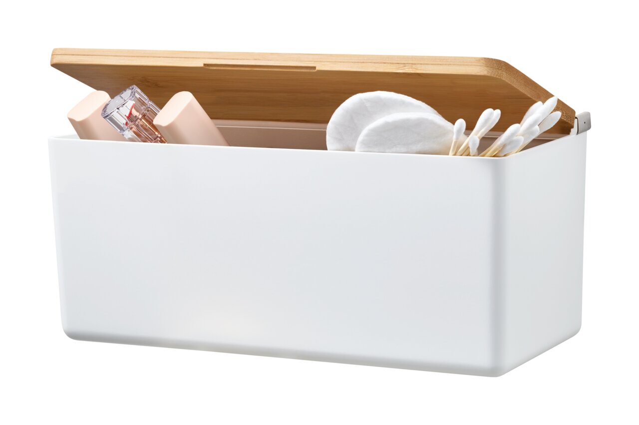 Witte opbergdoos met open houten deksel, gevuld met cosmeticaproducten en wattenschijfjes, zijaanzicht