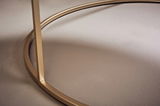 Nahaufnahme eines goldenen Couchtischgestells mit runder Basis, seitliche Perspektive.