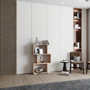 Modernes, asymmetrisches Standregal aus hellem Holz mit versetzten offenen Fächern, dekoriert mit Büchern, Vasen und Bilderrahmen, im Wohnzimmer-Setting; frontale Ansicht in leichter Schrägperspektive von links.