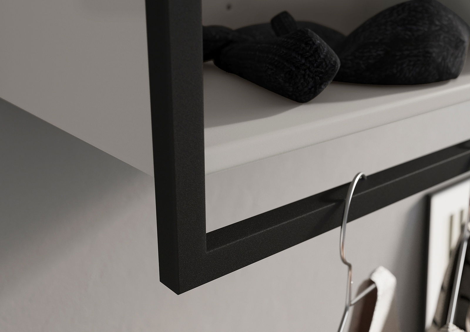 Nahaufnahme einer Garderobe mit schwarzem Metallrahmen und Haken, seitliche Perspektive.