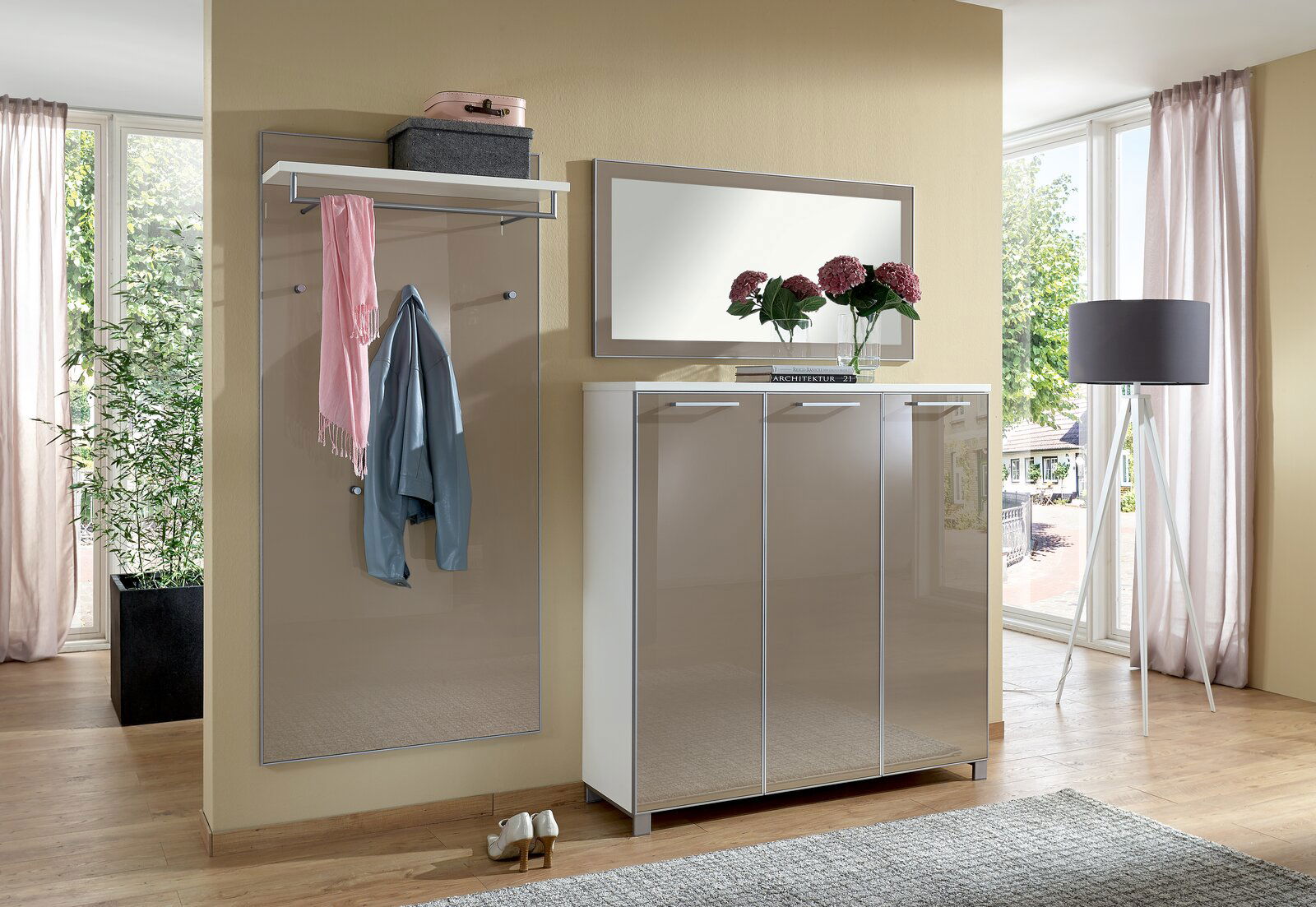 VOSS Garderoben-Set 3-tlg. SANTINA Modernes Garderoben-Set in einem hellen Raum mit großem Fenster, bestehend aus einem Spiegel, einer Garderobenleiste mit Ablage und einem dreitürigen Schrank. Perspektive von vorne.