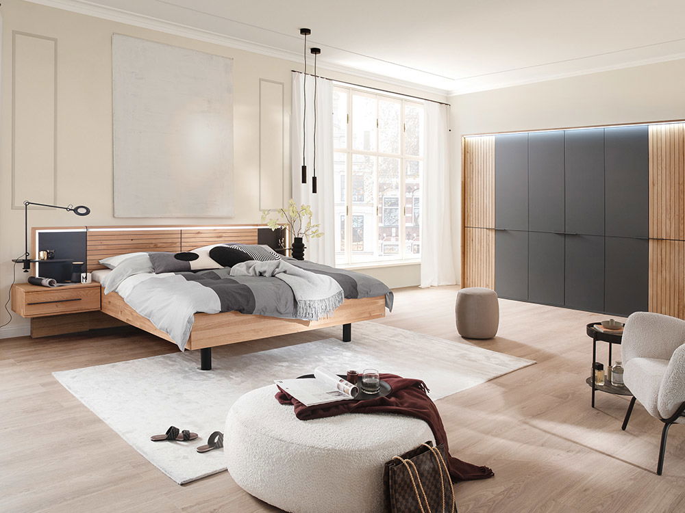 Helles Schlafzimmer mit Möbeln aus Holz mit anthrazitfarbenen Elementen.