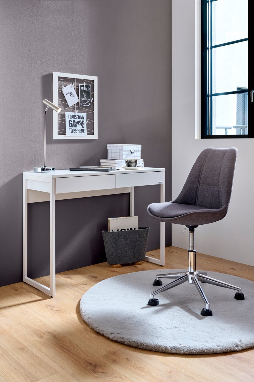 Moderner Schreibtisch in Weiß mit zwei Schubladen, seitliche Perspektive, ergänzt durch einen grauen Bürostuhl auf einem runden Teppich.