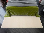 Beige Teppich vor einem Bett mit grüner Bettdecke, Vogelperspektive