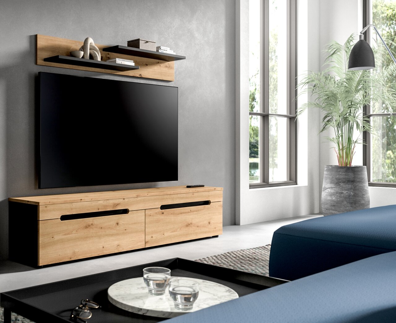 MID.YOU TV-Lowboard CANU Modernes TV-Lowboard aus hellem Holz mit schwarzen Griffleisten und seitlichen schwarzen Elementen, darunter ein großer Flachbildfernseher; Ansicht schräg von vorn links im Wohnzimmer.
