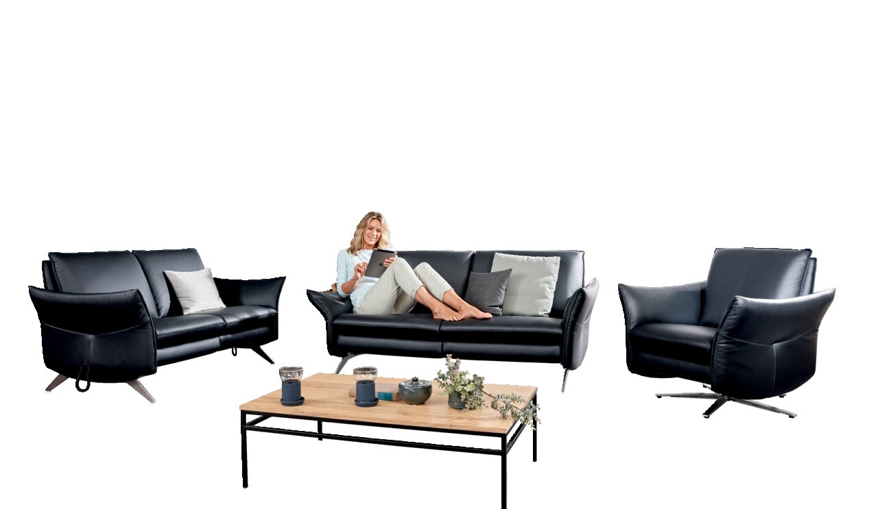 Himolla Fauteuil 7916 CUMUREX Woonkamerset met twee fauteuils en een bank in zwart leer, met een vrouw die op de bank zit en een tablet gebruikt. Vooraanzicht.