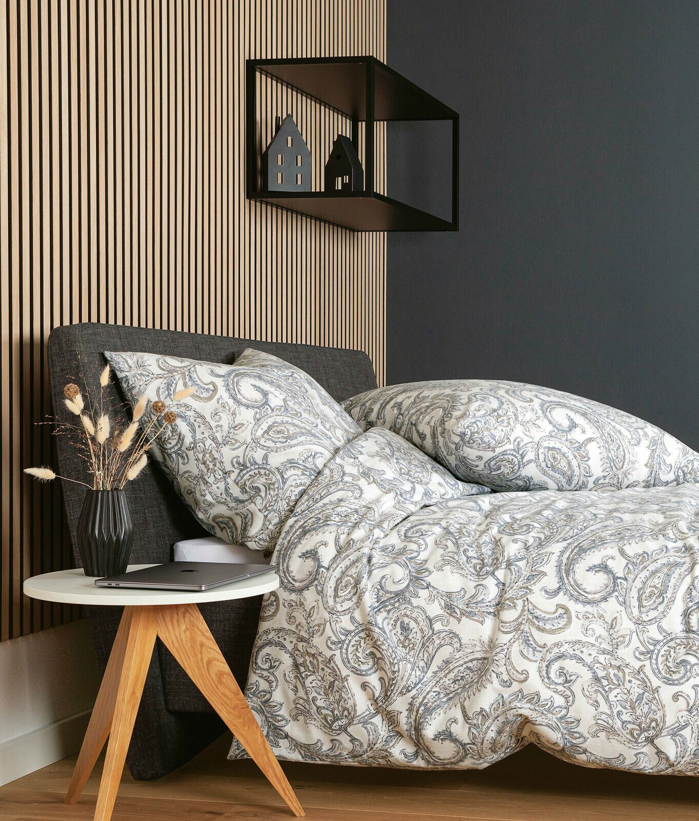 Bettwäsche-Set mit elegantem Paisley-Muster in Grau- und Beigetönen auf einem Bett, seitliche Perspektive, mit modernem Nachttisch und Dekoration.