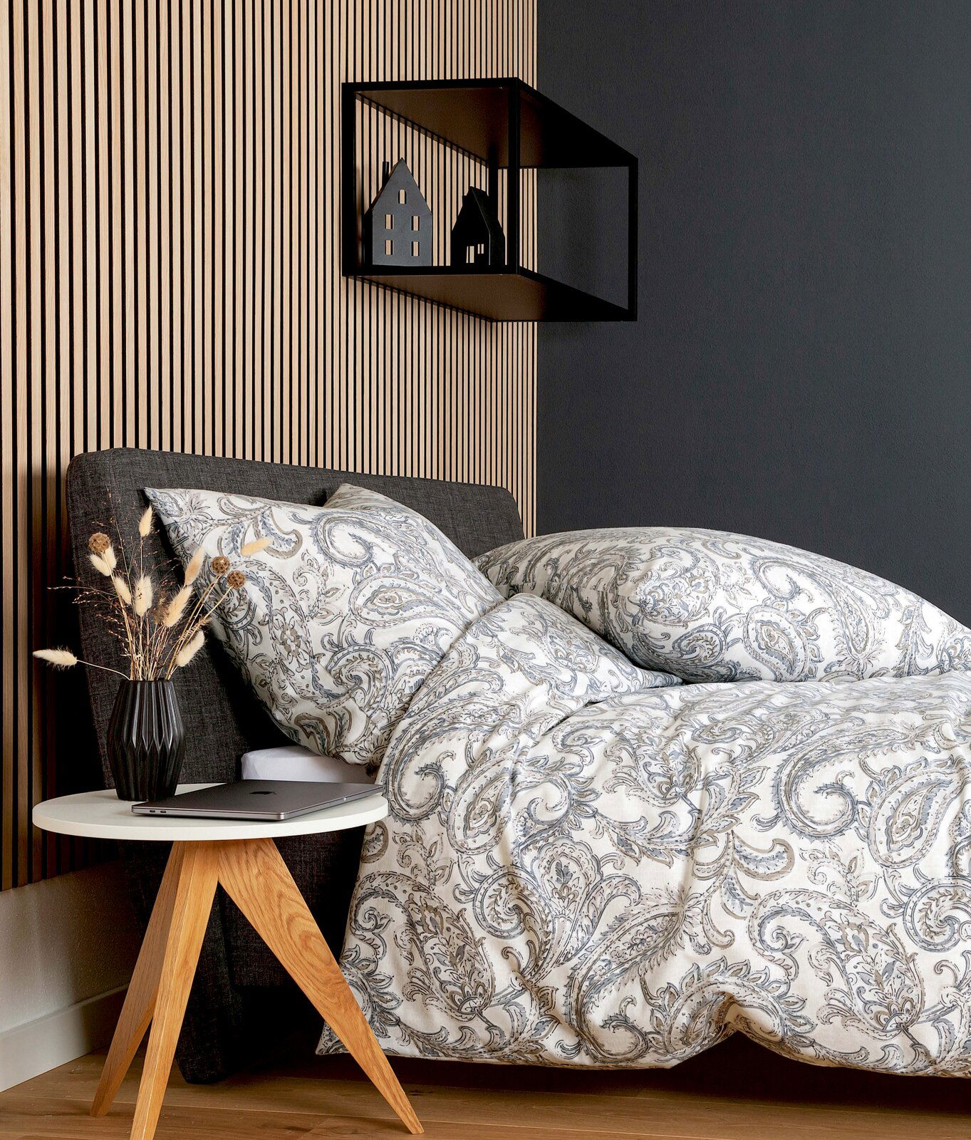 Bettwäsche-Set mit elegantem Paisley-Muster in Grau- und Beigetönen auf einem Bett, seitliche Perspektive, mit modernem Nachttisch und Dekoration.