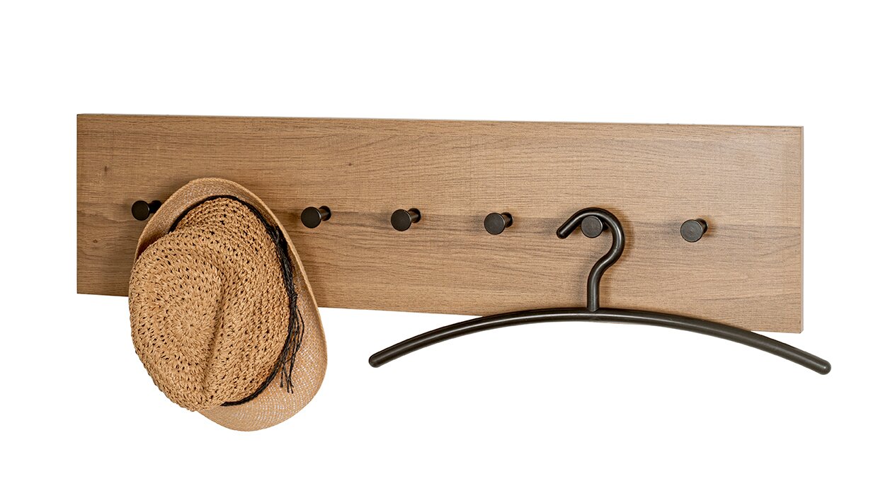 Zurbrüggen Wandgarderobe Wandgarderobe aus Holz mit mehreren schwarzen Haken, links ein Strohhut und rechts ein schwarzer Kleiderbügel, frontale Ansicht.