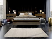 Handgewebter Teppich in einem modernen Schlafzimmer, frontal vor einem Bett platziert.