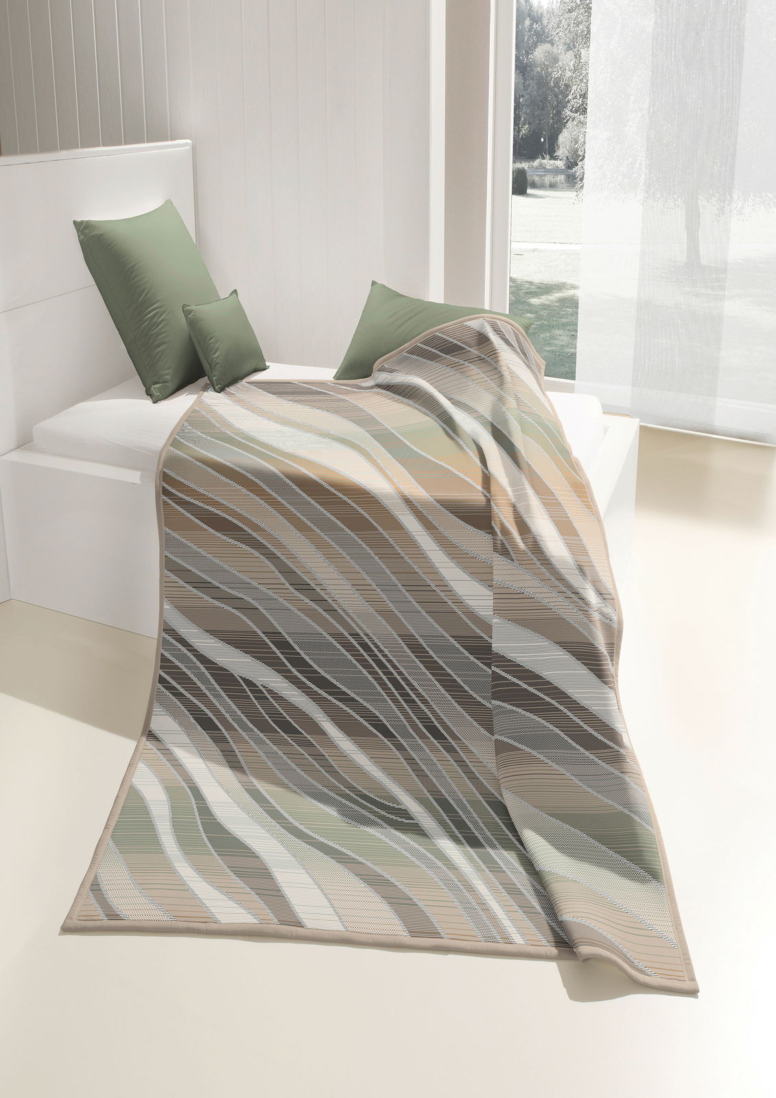 biederlack Woonkamerkleed COTTON HOME Wohndecke 150x200cm mit wellenförmigem Muster in Erdtönen, auf einem Bett drapiert, seitliche Perspektive.