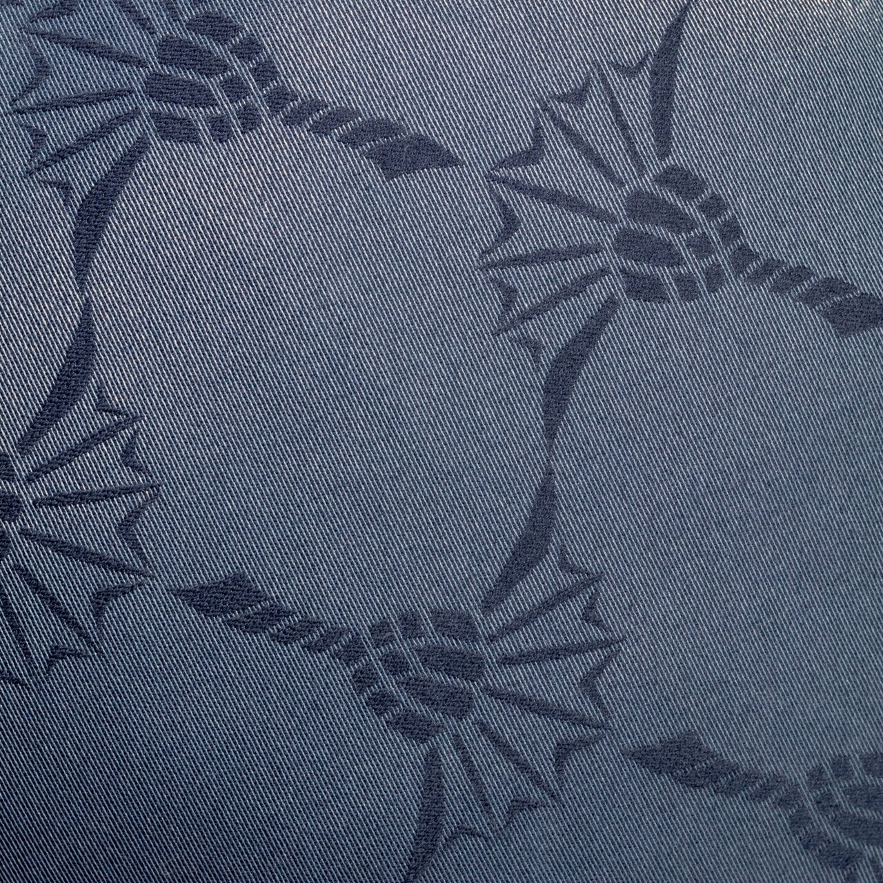 Nahaufnahme eines blauen Stoffes mit dekorativem Muster, verwendet für eine Yogarolle.