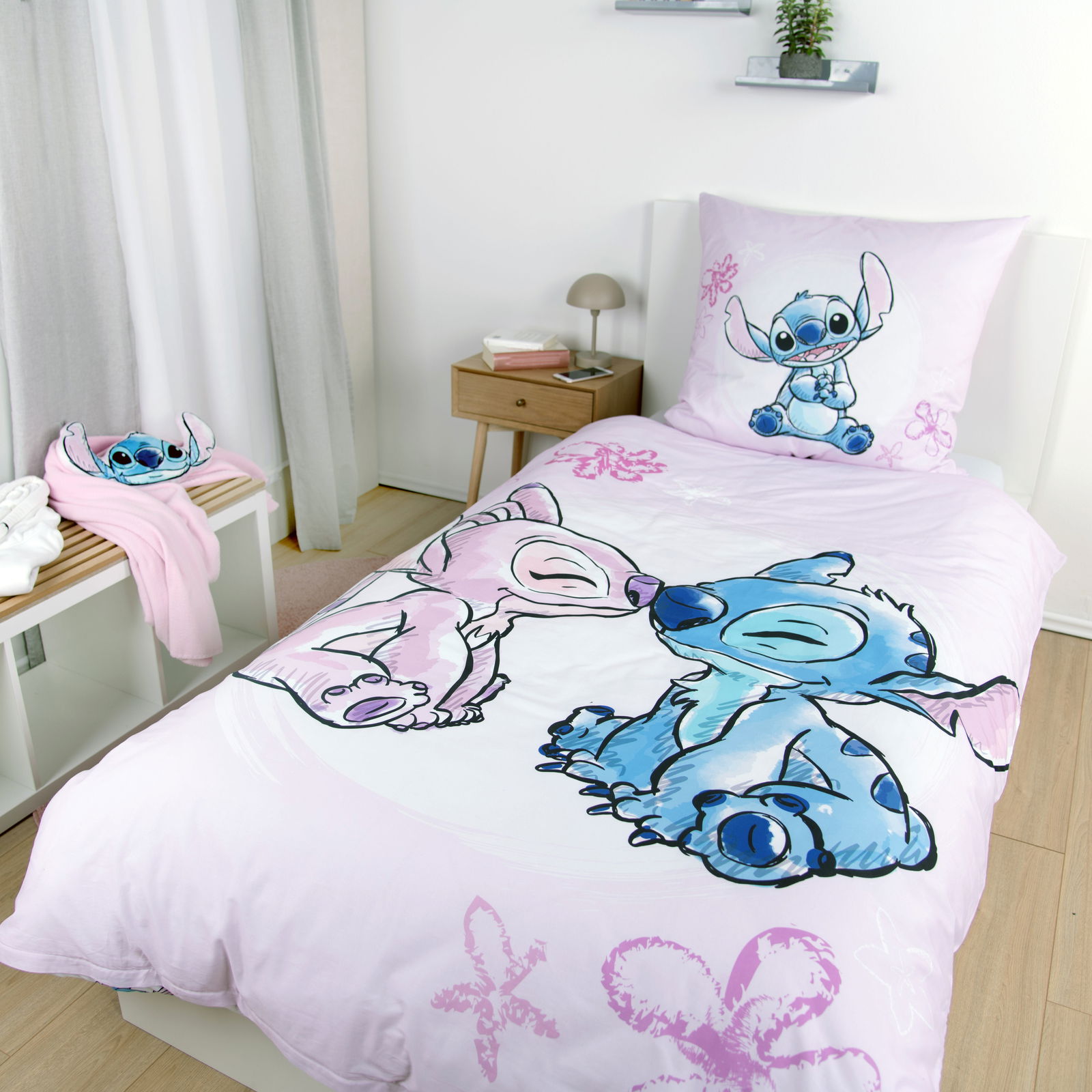 Renforcé-Bettwäsche mit buntem Cartoon-Motiv in einem modernen Schlafzimmer, aus der Vogelperspektive fotografiert.