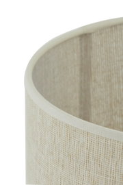 Close-up van een beige stoffen lampenkap met een gestructureerd oppervlak, gezien vanaf de zijkant