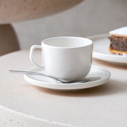 Weiße Kaffeeuntertasse Afina 14,2cm mit Tasse und Löffel, seitliche Perspektive