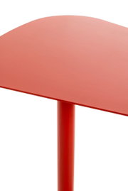 Roter Beistelltisch aus der Perspektive von oben, zeigt die Tischplatte und ein Tischbein.