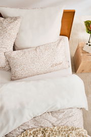 Satinbettwäsche-Set in Beige mit dezentem Muster, Draufsicht auf ein Bett mit Kopfkissen und Decke.