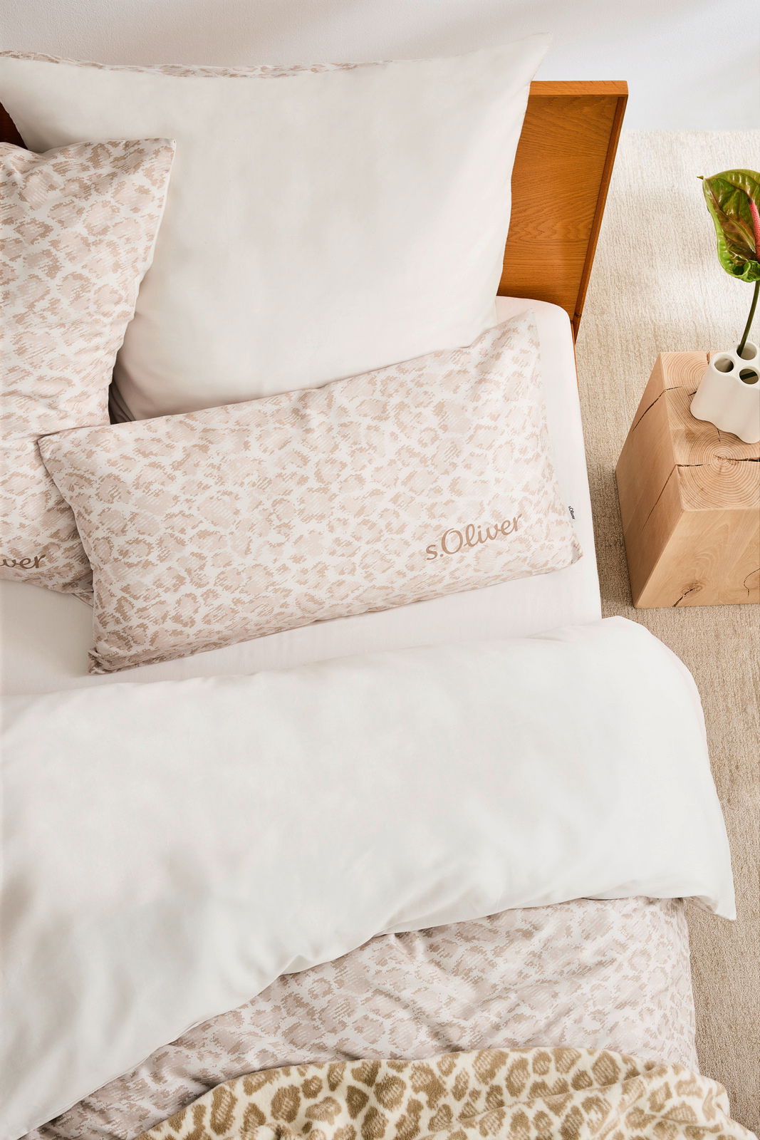 Satinbettwäsche-Set in Beige mit dezentem Muster, Draufsicht auf ein Bett mit Kopfkissen und Decke.