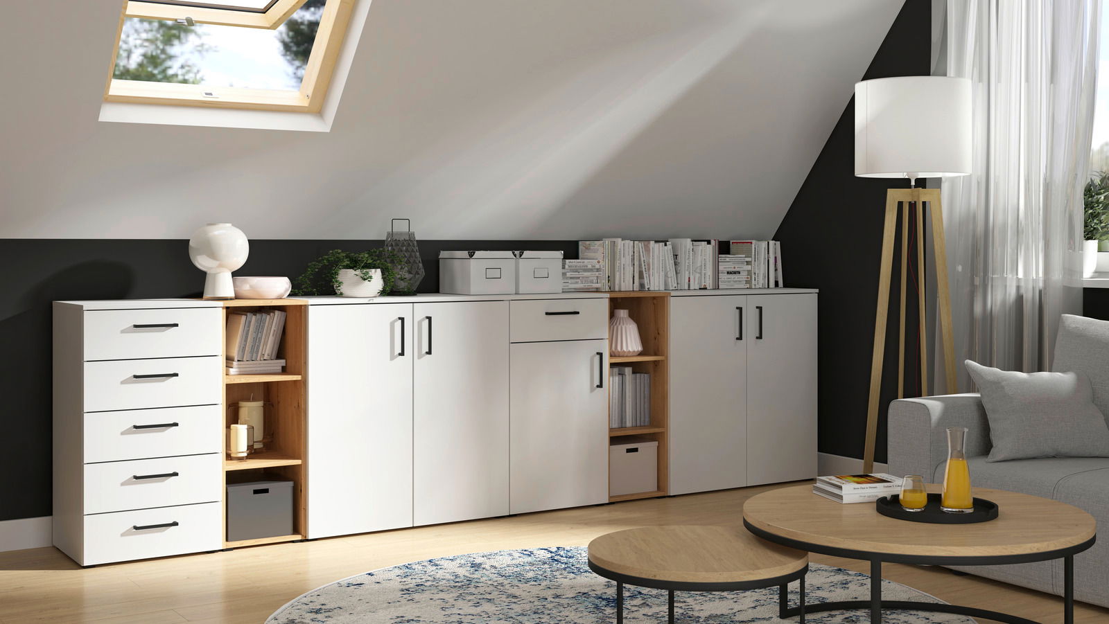 Moderne Wohnzimmermöbel mit weißen Schränken und Regalen, dekoriert mit Büchern und Pflanzen, in einem Raum mit Dachfenster und Stehlampe, seitliche Perspektive.