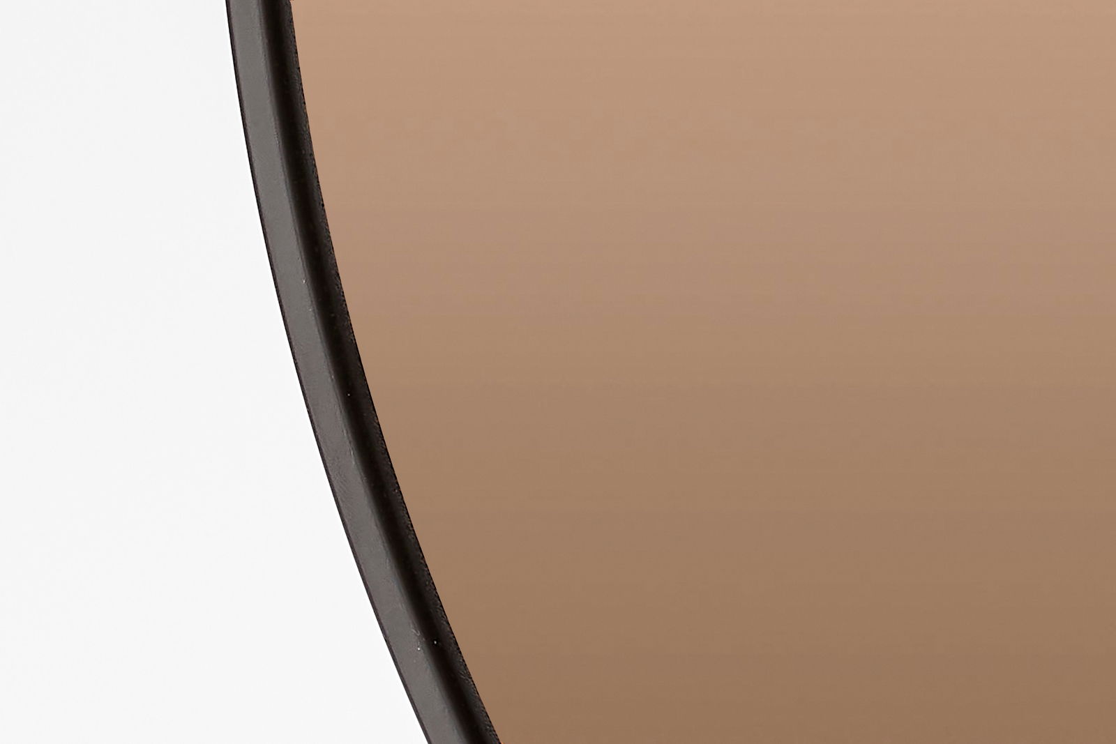 Nahaufnahme eines runden Spiegels mit schwarzem Rahmen, seitliche Perspektive