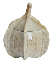 Keramische decoratieve doos in de vorm van een pompoen, gefotografeerd vanuit een zijaanzicht.