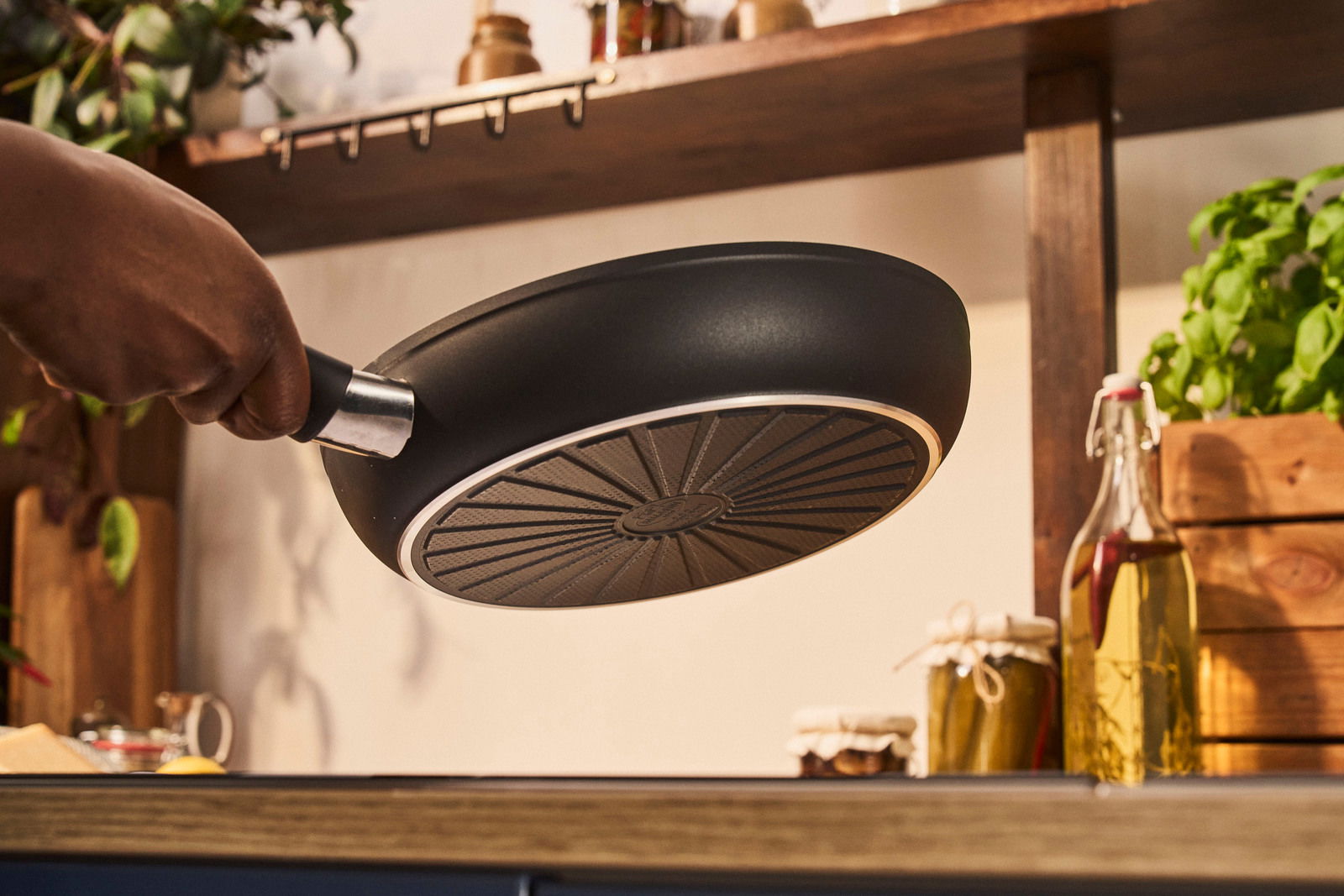 Bratpfanne mit 24 cm Durchmesser, von unten betrachtet, in einer Küche gehalten.