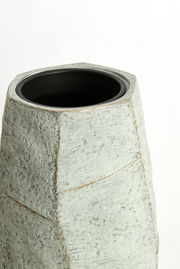 Moderner, grauer Topf mit rauer Oberfläche, aus einer leicht erhöhten Perspektive fotografiert.