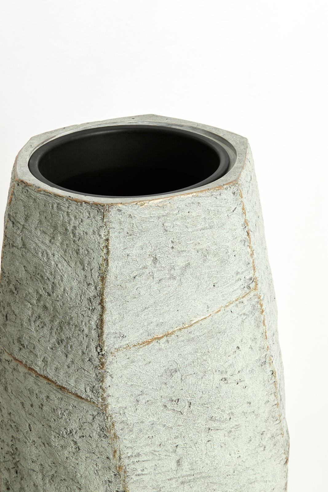 Moderner, grauer Topf mit rauer Oberfläche, aus einer leicht erhöhten Perspektive fotografiert.