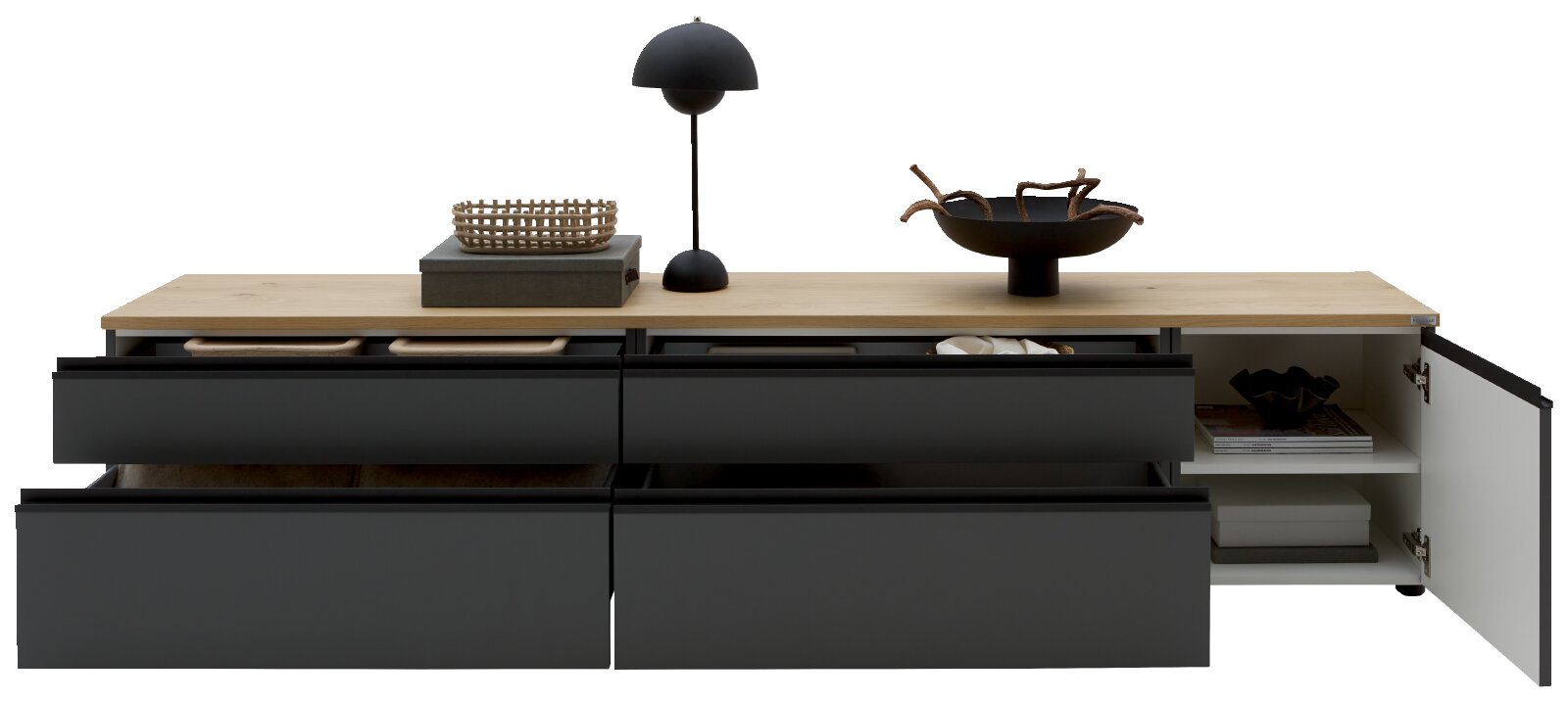 Modernes Sideboard/Lowboard mit schwarzer Front und heller Holzplatte, vier Schubladen und offenem Fach mit rechts geöffneter Tür, dekoriert mit Lampe und Schalen, frontal in leichter Aufsicht auf weißem Hintergrund