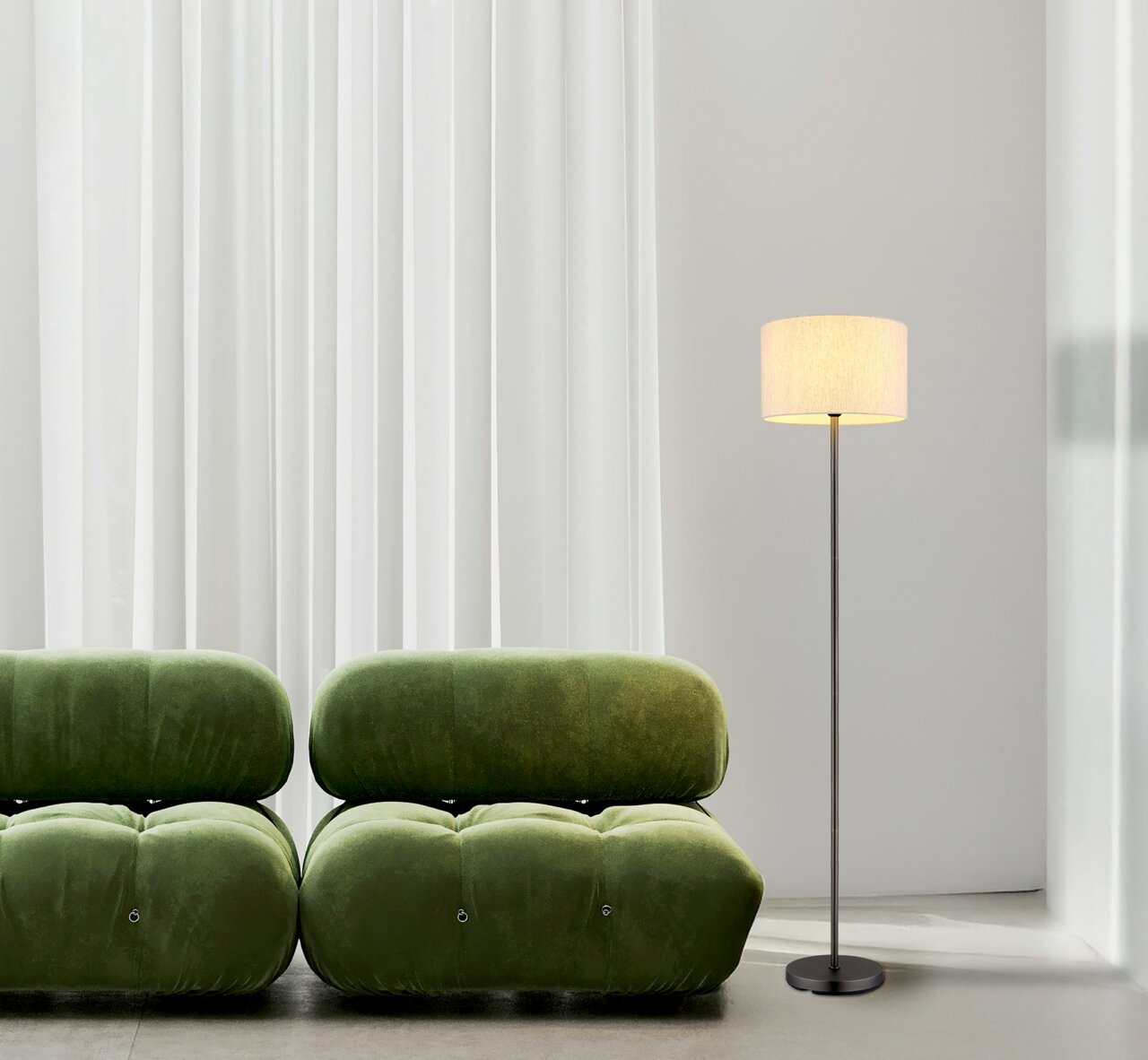 Staande lamp met een strak ontwerp, geplaatst naast een groene bank voor witte gordijnen, gezien vanuit de zijkant.