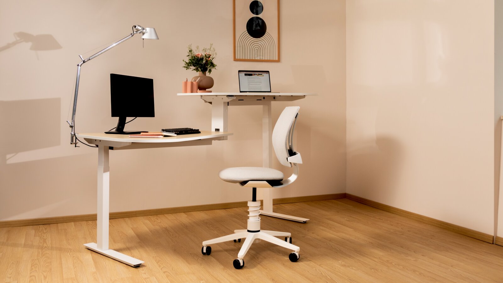 Modernes Homeoffice mit weißem höhenverstellbarem Schreibtisch, Monitor und silberner Schreibtischlampe sowie ergonomischem Bürostuhl auf Rollen; Perspektive: seitliche 3/4-Ansicht von links.