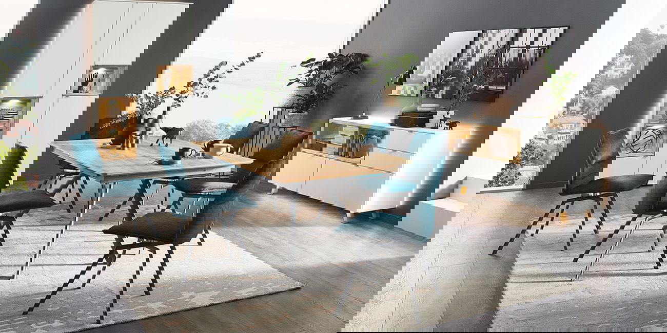 Ein stilvolles Esszimmer mit Holztisch, blauen Stühlen, weißen Möbeln und großen Fenstern mit Ausblick.