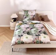 Wendebettwäsche mit floralem Muster in Pastelltönen auf einem Bett, fotografiert aus der Vogelperspektive.