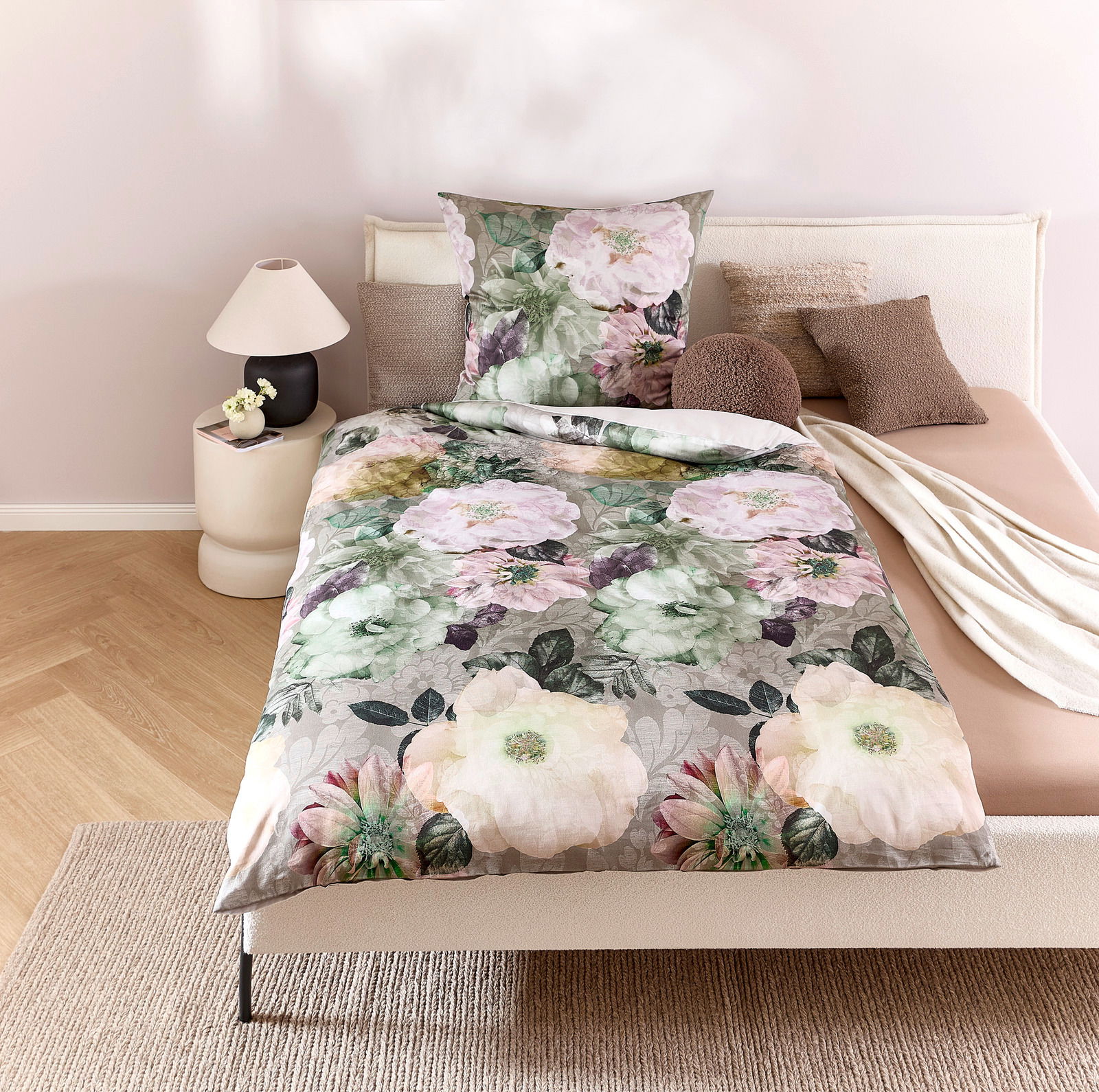 Wendebettwäsche mit floralem Muster in Pastelltönen auf einem Bett, fotografiert aus der Vogelperspektive.