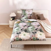 Wendebettwäsche mit floralem Muster in Pastelltönen auf einem Bett, fotografiert aus der Vogelperspektive.