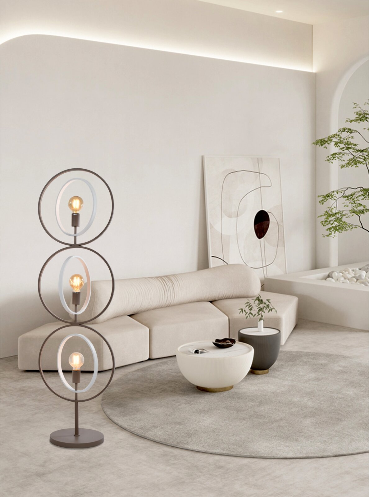 Moderne bruine vloerlamp met drie verlichte glazen ringen, vanuit schuin vooraanzicht in een lichte, minimalistische woonkamer