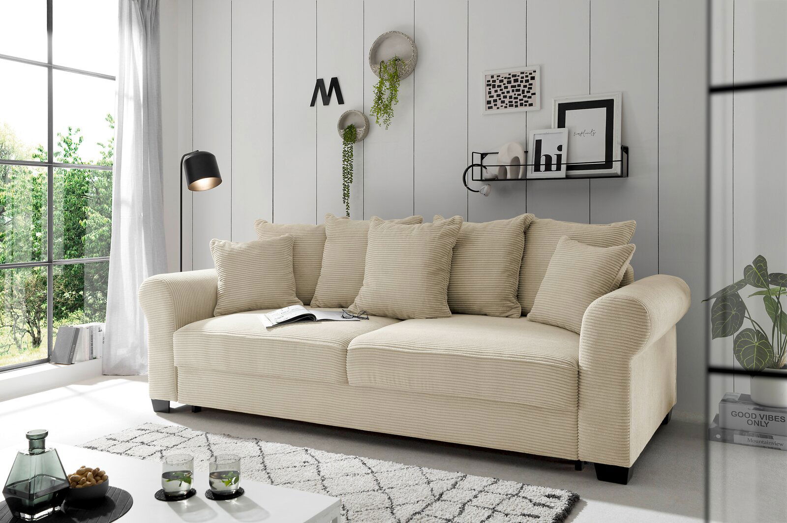 Beiges Funktionssofa in einem modernen Wohnzimmer, seitliche Perspektive, mit Kissen und dekorativen Elementen.