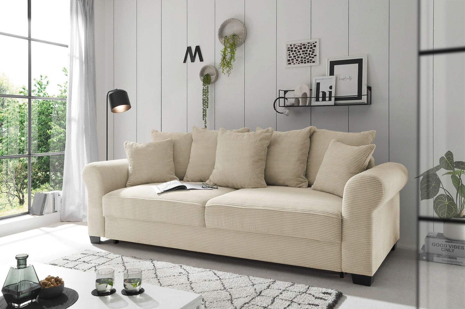 Beiges Funktionssofa in einem modernen Wohnzimmer, seitliche Perspektive, mit Kissen und dekorativen Elementen.